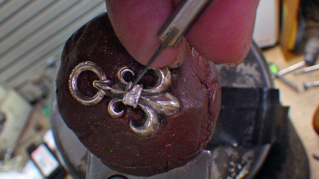 毛彫りタガネでサファイヤの石座を彫っている様子